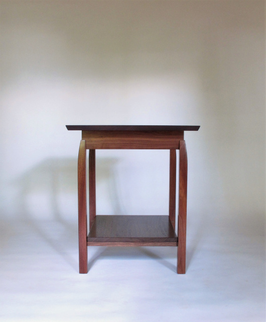 This solid walnut side table has a shelf for storage or display.  Our handmade wood furniture works well in small spaces